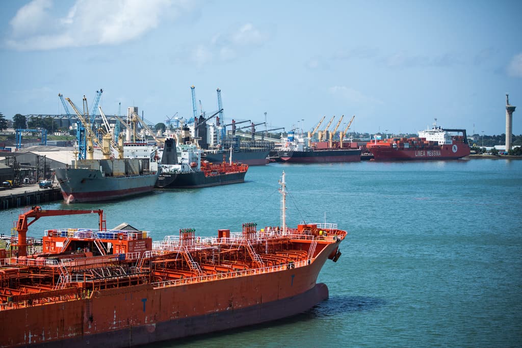 Red tanker alongside the quay with cranes and warehouses at the Port of Mombasa