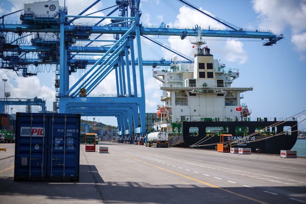 Cargo ship docked beside gantry cranes and a container at the Port of Mombasa