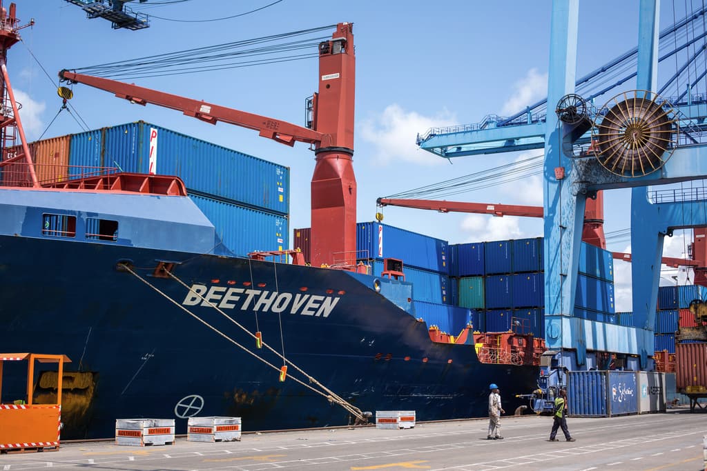 Large cargo ship at the quay beneath port cranes at the Port of Mombasa